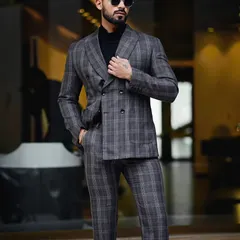 This shot captures a model in a double-breasted suit against a modern architectural backdrop. The composition highlights the clean lines of the suit and the model's confident presence.