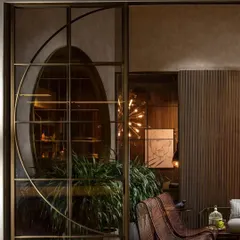 A detailed view of the custom metalwork, where a geometric arc detail adds an artistic, bespoke element to the glass partition. This showcases how I integrate unique design motifs into functional architectural features.