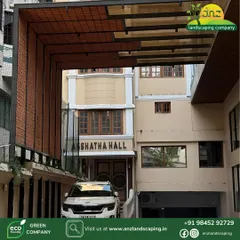 This angle shows the pergola with a car parked underneath, illustrating its practical function as a stylish carport while framing the entrance to the hall.
