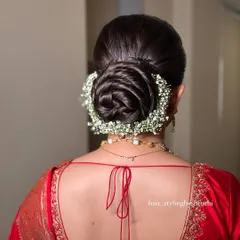 This is a detailed look at a floral rose bun, crafted with precision and encircled by delicate baby's breath. It's a popular and elegant choice for brides and is suitable for receptions and other formal events.