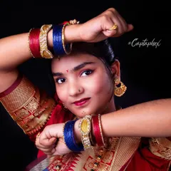 This portrait uses a dynamic pose, with the hands framing the face to draw attention to the colorful bangles and expressive eyes. It's a lively take on traditional portraiture.