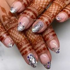 A perfect example of how glitter can elevate a bridal look. This design features a soft, natural base with a chunky silver glitter gradient, which looks stunning against the deep color of the henna.