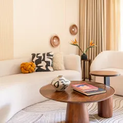 A closer view of the custom coffee table and curved sofa, showcasing the interplay of organic shapes and natural materials that define this home's Wabi-Sabi style.
