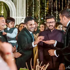 The ring is found. The groom's brothers and friends share a laugh as the ring is finally presented for the ceremony.