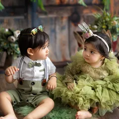 A candid moment between two little friends. Their curious expressions and adorable outfits make this a truly special photograph.