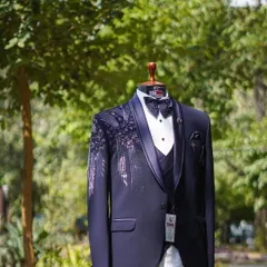 This navy blue 3-piece tuxedo is a testament to my craft, featuring unique feather-like embroidery on the shoulder. It's a designer suit that blends classic tailoring with artistic flair.