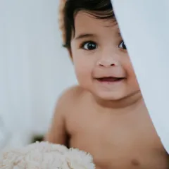 Peek-a-boo. This nine-month-old's playful smile is just infectious. Sitter sessions are so much fun, capturing them as they explore and play.