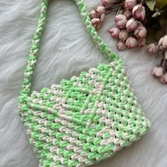 This shoulder bag features a fresh look with its neon green and off-white checkered pattern. The design is lightweight and the strap is knotted for extra durability.