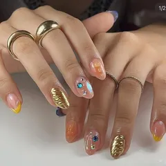 This design combines metallic gold textures, colorful gems, and a transparent base. Learning to balance multiple elements is key to creating luxurious, eye-catching nail art.