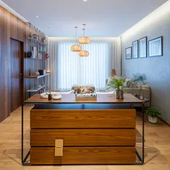 A custom-designed chest of drawers, crafted from wood with a sleek metal frame, acts as a functional divider between the living and dining areas. It defines the space without creating a solid visual barrier.