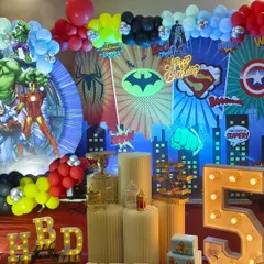 For the ultimate superhero fan, I created this action-packed Avengers birthday party stage. The setup features a dynamic city skyline backdrop, multiple superhero cutouts including the Hulk and Iron Man, themed balloon arrangements, and a large light-up number '5'.