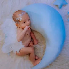 This angelic theme is a beautiful way to portray the innocence of a newborn. With delicate wings and a celestial moon prop, I create a dreamy, peaceful scene that looks like it's straight out of a storybook.