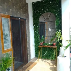 To make this entrance balcony feel special, we installed a beautiful arch-shaped mirror against a green wall. It makes the space feel larger and adds a touch of elegance right at the front door.
