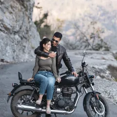 A romantic moment on a motorcycle, set against the rocky cliffs of a mountain road. I focus on capturing the connection between the couple, even in a themed shoot like this.