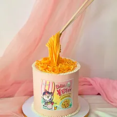 This version of the ramen cake is inspired by the popular cheesy Buldak noodles. The "floating" chopsticks and detailed packaging are all part of the edible illusion.