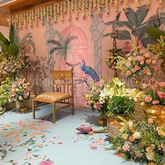 I adore bringing unique artistic visions to life, like this Pichwai-inspired backdrop for a pre-wedding celebration. The hand-painted details, combined with fresh flowers, banana plants, and traditional brass lamps (kuthu vilakku), create an elegant and culturally rich setting.