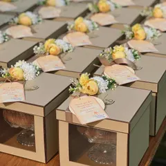Another beautiful set of baby announcement favours. These kraft-style boxes are decorated with yellow and white floral arrangements and a personalized tag celebrating the upcoming arrival of "Baby Sethi".