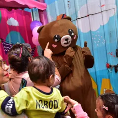 A toddler meets our friendly bear mascot. These gentle giants are always a huge hit with the youngest guests, providing lots of hugs and great photo moments.