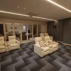 A view from the back of the home theater, showing the tiered seating arrangement and the soft profile lighting that sets the perfect ambiance.