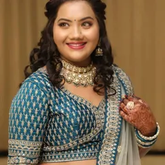 A close-up of a happy client wearing an elegant choker necklace that perfectly matches her teal lehenga.