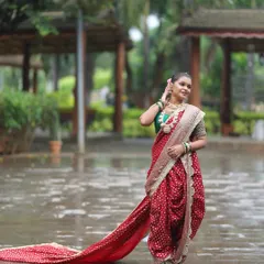 Make a grand entrance with this beautiful red bandhani-style Nauvari. The long, flowing 'shetar' or trail adds a touch of royal elegance, ideal for pre-wedding photoshoots or for a bride who wants a dramatic look.