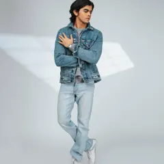 A full-length shot that showcases the entire outfit, including the fit of the jeans and the shoes. The lighting effect adds a subtle creative touch.
