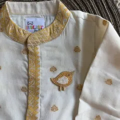 This cream kurta set is perfect for festive occasions. It’s crafted from breathable fabric with subtle gold butis and a hand-embroidered bird brooch for a touch of charm.