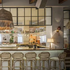 For the EVE restaurant in Powai, we crafted an atmosphere of nostalgic comfort and vintage charm. This view of the bar highlights our use of natural textures like rattan and woven light fixtures to create a warm, inviting social hub. The design encourages connection, making it a space people want to return to.