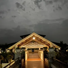 As dusk settles, the retreat transforms into a tranquil haven. The warm lights of our main hall offer a welcoming glow against the dramatic night sky, creating a perfect atmosphere for evening meditation.