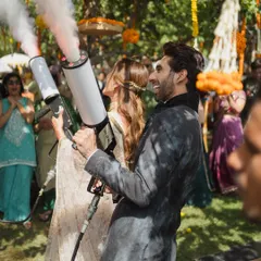 Let's make it fun! The couple makes a memorable entrance at their Mehendi party using color smoke guns, adding a modern and playful twist to the celebration.