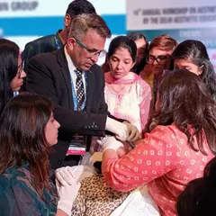 A live hands-on demonstration during a training session. Participants gather closely to observe and learn the precise techniques for injectable treatments, fostering a collaborative and intensive learning environment.