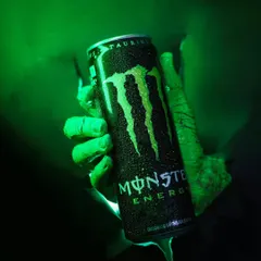 Unleash the beast energy. A close-up of the final shot, showing the Monster can bursting through the background with dramatic green lighting and water droplets for effect.