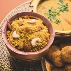A close-up of Dal Bati Churma, a cornerstone of Rajasthani cuisine. We prepare this dish with authentic techniques, offering the perfect balance of savory dal, baked bati, and sweet churma.