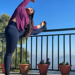 While traveling, a little stretch is a must to relieve stiffness. Here I am using a railing for a standing split variation, enjoying the fresh mountain air and the beautiful view.
