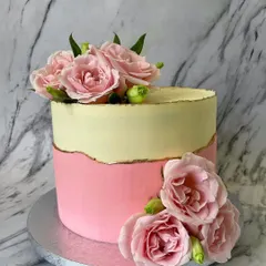 A simple and beautiful design featuring two-toned pastel pink and yellow buttercream with a delicate fault line edged in gold. The fresh pink roses add a touch of natural beauty.