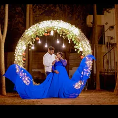 Creating magic for a maternity shoot. This royal blue trail gown features integrated LED lights, perfect for a memorable nighttime photoshoot that highlights the joy of expecting.