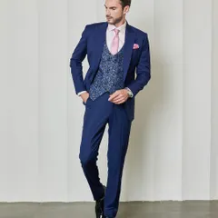 This navy three-piece suit features a contrasting jacquard fabric waistcoat, adding a layer of texture and personality. The pink shirt and accessories provide a modern pop of color to a classic ensemble.