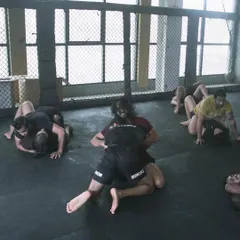 Multiple pairs of students are engaged in live grappling drills. This controlled sparring is crucial for applying techniques under pressure and building the muscle memory needed for effective ground fighting.