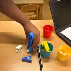 This occupational therapy engagement focuses on developing a tripod grasp, a key fine motor skill for writing. By using clips to pick up and sort objects, the child strengthens intrinsic hand muscles and improves precision.