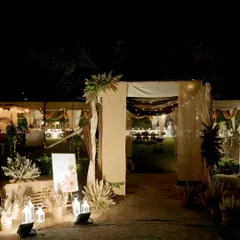 The entrance to a magical 25th anniversary party. We used soft drapes, pampas grass arrangements, and warm lanterns to create an inviting and romantic entryway for the guests.