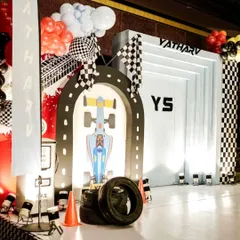We transformed the space into a high-octane race track for a little hero's 5th birthday. This setup features a custom race car photo booth, track-style flooring, and checkered flag details, showing how we bring high-energy themes to life with complete immersion.