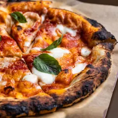 You can never go wrong with a classic, the kind that wraps around you like an old, distant memory. This is our Margherita pizza, with its perfectly charred crust, rich tomato sauce, and fresh basil. It’s the quiet joy of your very first slice, remade just for you.