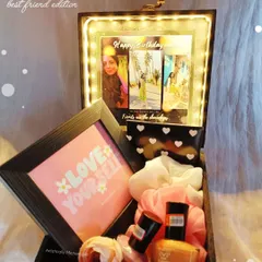 A birthday hamper for a best friend, featuring a light-up photo display, a 'Love Yourself' frame, nail polish, and scrunchies.