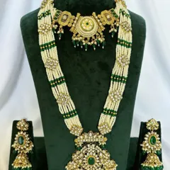 A grand Rani Haar made with multiple strands of pearls and green beads, featuring Kundan motifs. This rental set comes with a matching choker and earrings.