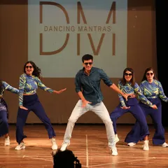A cool, coordinated moment from a modern Bollywood performance. This shot captures the confidence and style of our adult performers as they command the stage with their synchronized moves.