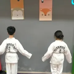 Ready for action. Two of my Taekwondo champs stand prepared in their official uniforms, showcasing the discipline and focus that we instill in every martial arts class for children.