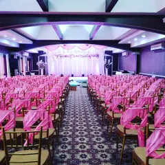 For large-scale events, we ensure the seating arrangement is both practical and beautiful. Here, hundreds of chairs are neatly arranged and decorated with pink sashes, leading the eye towards the main stage.