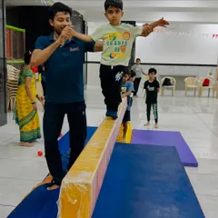 Building balance starts with small, confident steps. I am here to offer a steady hand and encouragement as this little one learns to navigate the balance beam, turning a challenging task into a fun game.