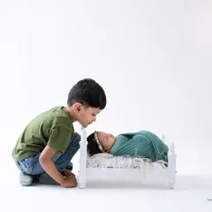 A slightly different angle of this precious moment, showing the big brother's curiosity and gentleness. I always aim to capture multiple perspectives of these fleeting interactions.