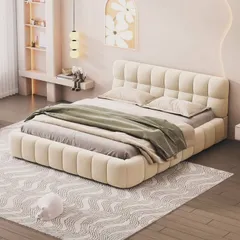A modern, fully-upholstered bed with vertical channel tufting on the headboard and frame. This low-profile design creates a soft, cloud-like look for a contemporary bedroom.